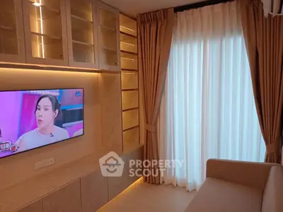 Modern living room with built-in shelves, TV, and elegant curtains