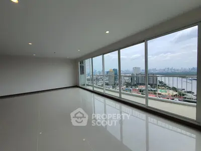 Spacious living room with stunning city skyline and river view through floor-to-ceiling windows.