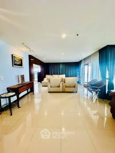 Spacious living room with elegant decor and large windows offering natural light.