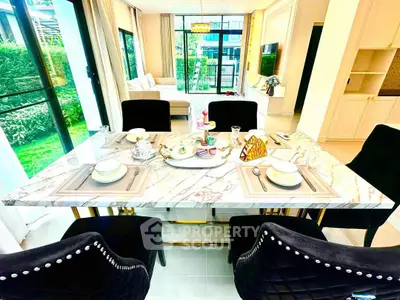 Luxurious dining area with elegant marble table and plush chairs, overlooking a lush garden view.
