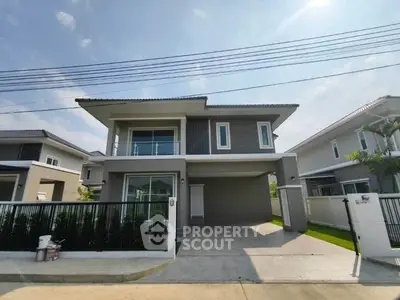 Modern two-story house with spacious driveway and sleek exterior design.