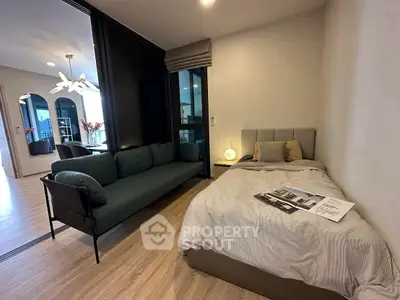 Modern studio apartment with cozy bed and stylish sofa, featuring open layout and elegant decor.