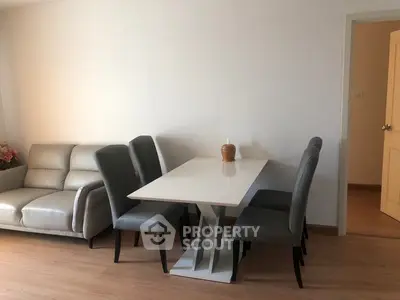 Modern living room with sleek dining table and comfortable sofa, perfect for stylish urban living.