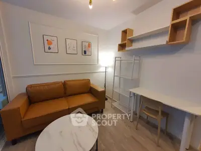Modern living room with stylish decor, featuring a cozy brown sofa, elegant wall art, and functional shelving.