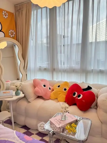 Charming living room with plush sofa and playful decor, featuring large windows for natural light.
