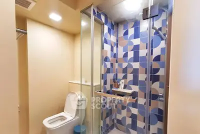Modern bathroom with geometric tile shower and sleek fixtures