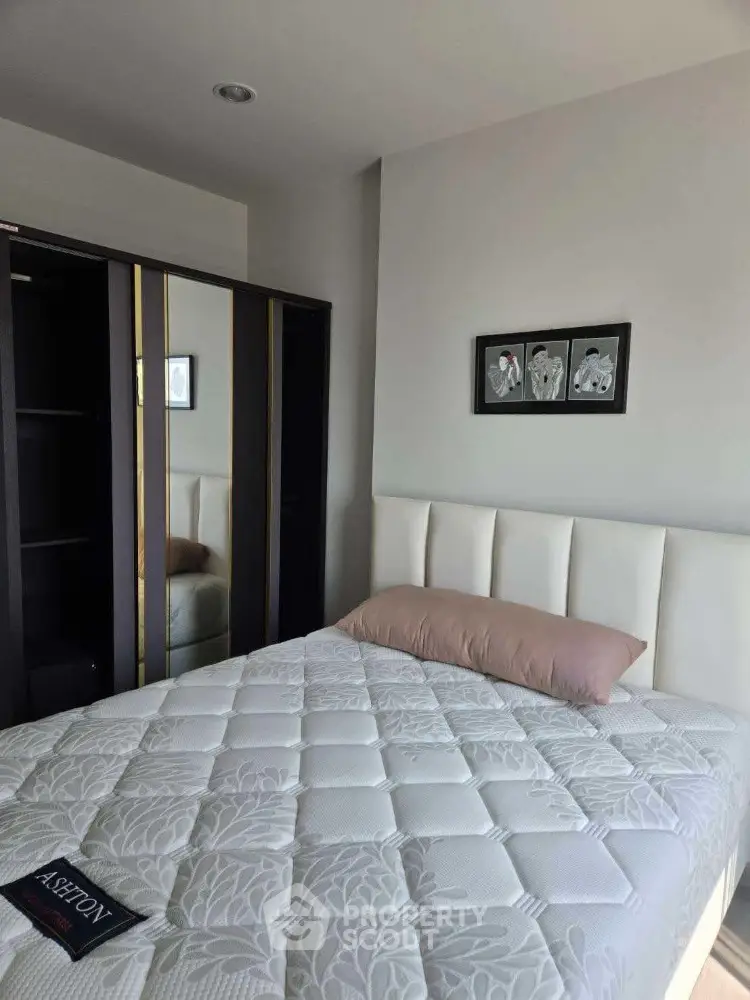 Modern bedroom with stylish decor and mirrored wardrobe in a cozy apartment