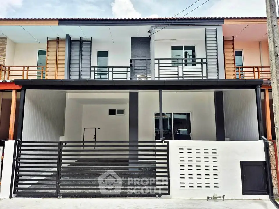 Modern two-story townhouse with sleek design and gated entrance