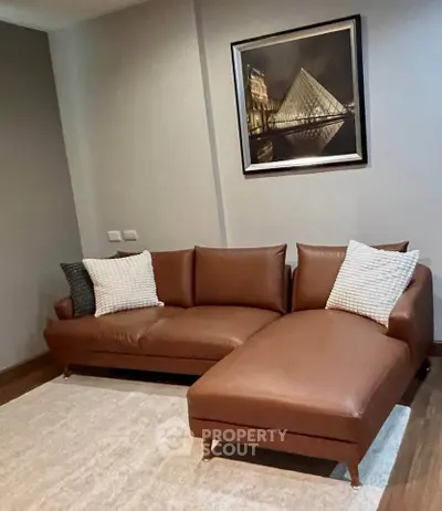 Stylish living room with modern brown leather sofa and elegant wall art.