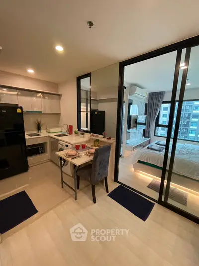 Modern open-plan kitchen and dining area with view into stylish bedroom