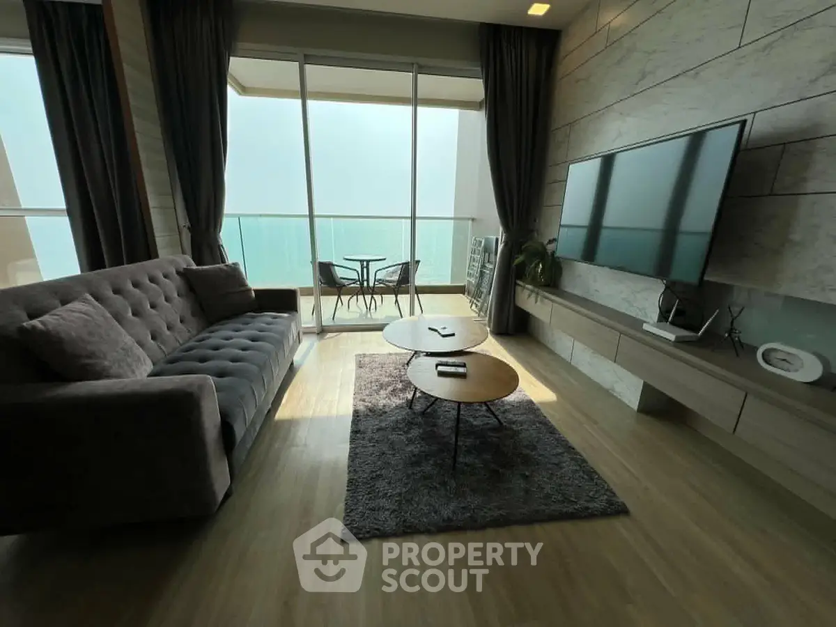 Luxurious living room with modern decor and balcony view, featuring sleek furniture and elegant design.