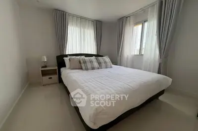 Modern bedroom with large windows and elegant curtains in a stylish apartment.