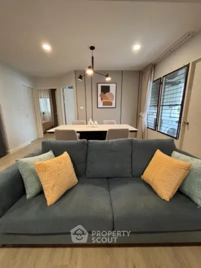 Modern living room with stylish sofa and dining area, perfect for cozy gatherings.