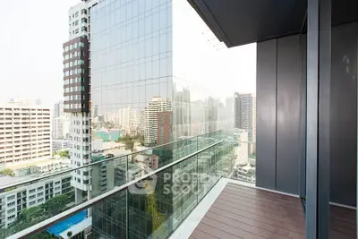 Modern high-rise balcony with stunning cityscape view and glass railing.