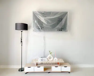 Modern living room with TV, stylish lamp, and minimalist decor