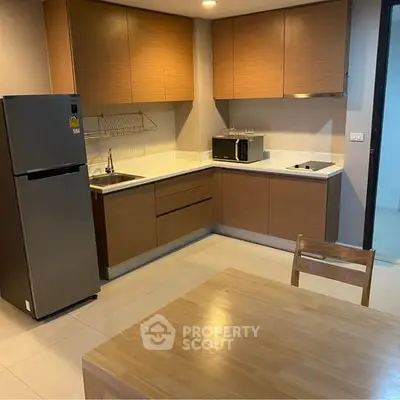 Modern kitchen with sleek cabinets and appliances in cozy apartment.