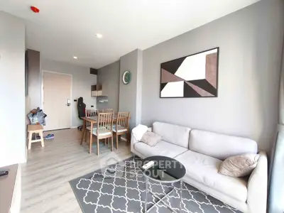 Modern living room with stylish decor and dining area in open layout apartment.
