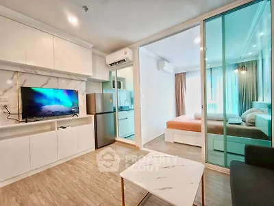 Modern apartment interior with open living room, kitchen, and bedroom featuring sleek design and natural light.