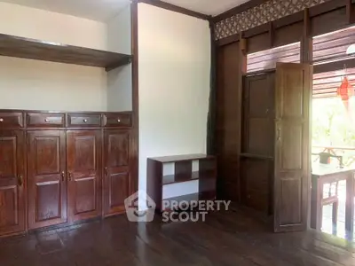 Charming wooden interior with built-in cabinets and natural light, perfect for cozy living.