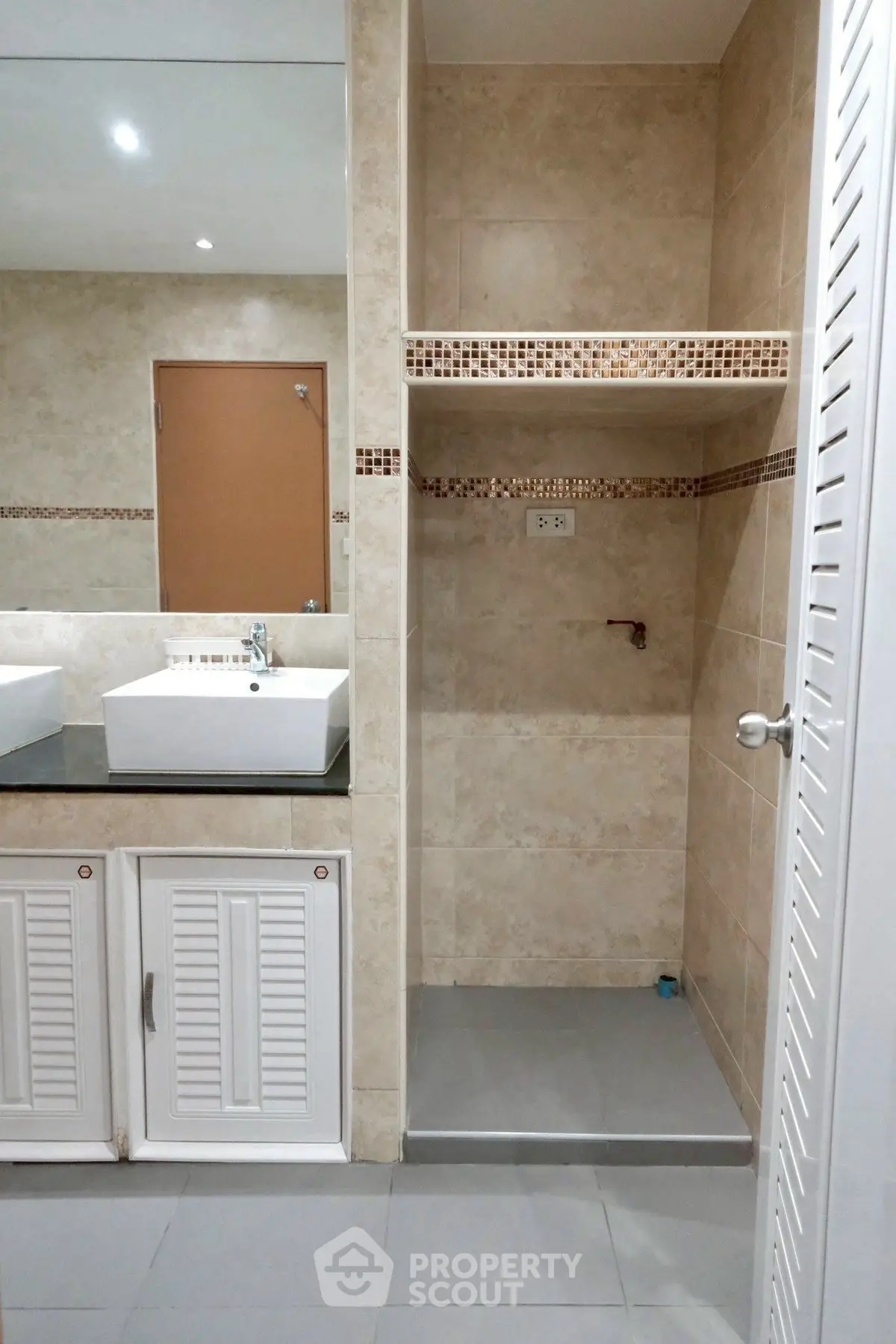 Modern bathroom with dual sinks and spacious shower area in elegant beige tiles.