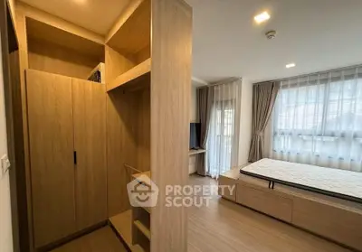 Modern bedroom with wooden flooring, built-in wardrobe, and large windows for natural light.