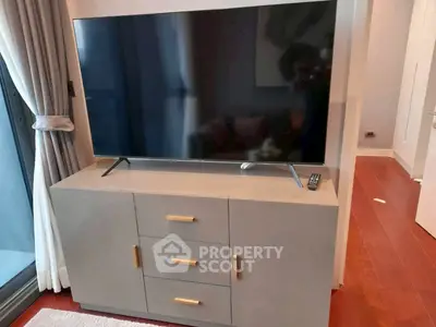 Modern living room with sleek TV stand and large flat-screen TV, perfect for entertainment.