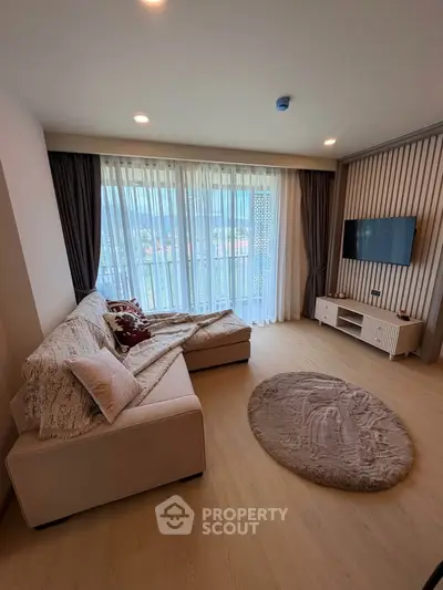 Spacious living room with modern decor and large windows offering natural light.