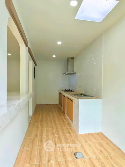 Modern kitchen with sleek design, featuring gas stove and wooden cabinetry, perfect for culinary enthusiasts.