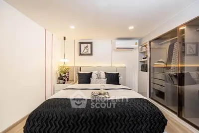 Modern bedroom with stylish decor and mirrored wardrobe in a cozy apartment.