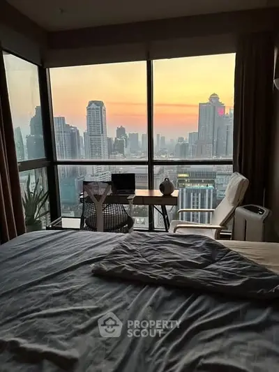 Stunning city view from a modern bedroom with large windows and cozy workspace.
