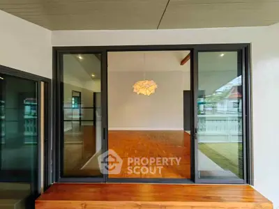 Spacious modern living room with large glass doors and wooden flooring