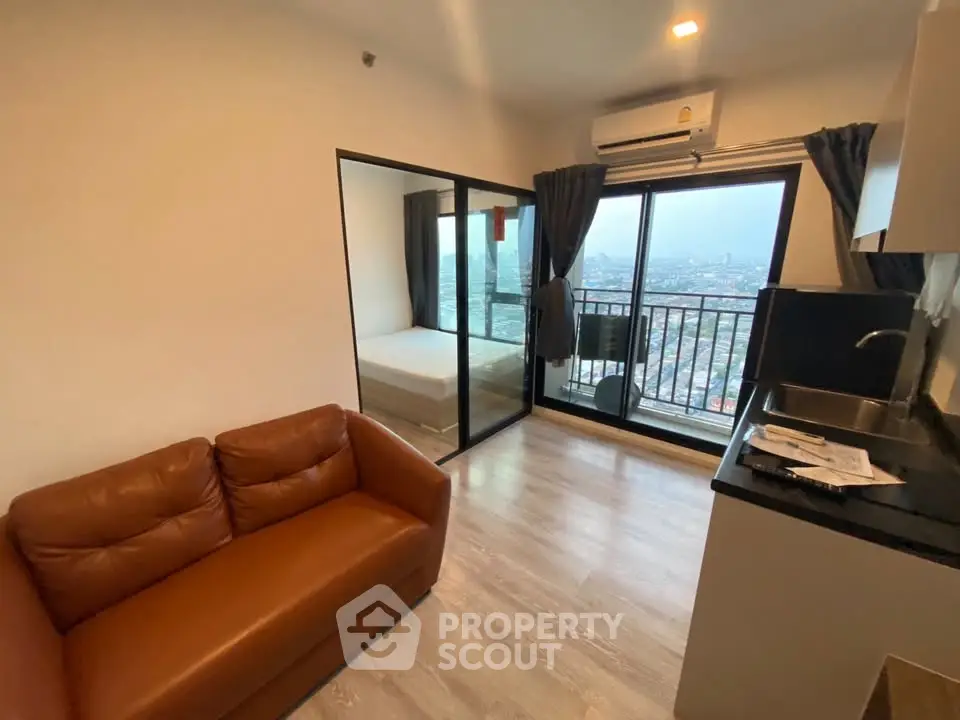 Modern apartment with open layout, featuring a cozy living area, compact kitchen, and a balcony with city views.