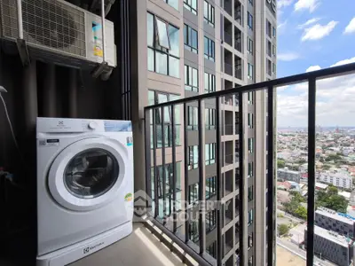 Modern high-rise apartment balcony with washing machine and city view