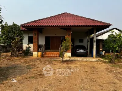 Charming single-story home with red-tiled roof and spacious front yard.