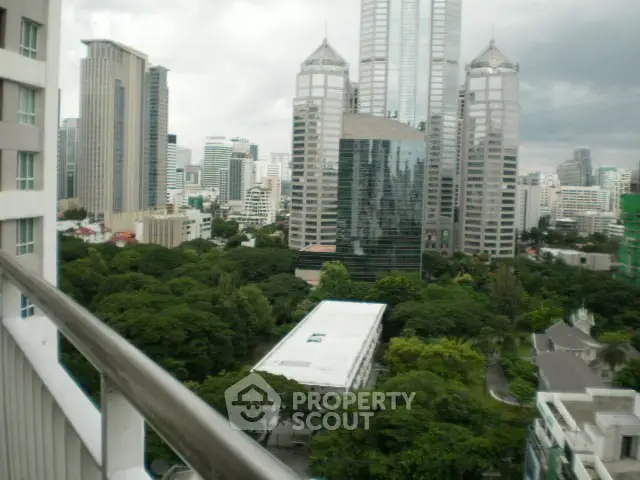 Stunning cityscape view from a high-rise balcony overlooking lush greenery and modern skyscrapers.