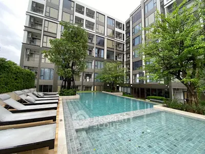 Luxurious apartment complex with modern pool and lush greenery