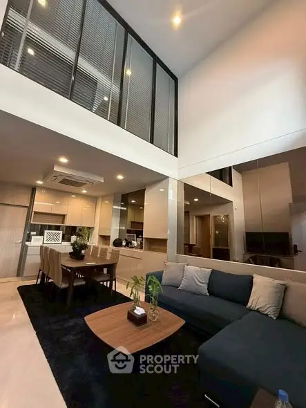 Modern living room with high ceiling and open kitchen layout