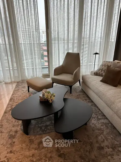 Elegant living room with modern furniture and large windows offering city views.