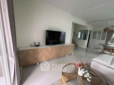 Modern living room with stylish furniture and large TV, perfect for relaxation.