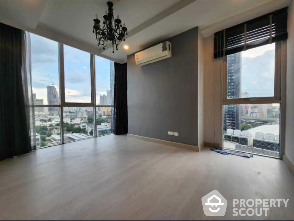 Spacious corner unit with stunning city view and modern chandelier in living room.