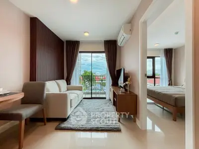 Modern living room with cozy sofa, TV, and balcony view in stylish apartment.