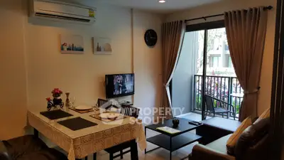 Cozy living room with dining area and balcony access in modern apartment.