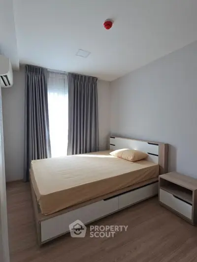 Modern minimalist bedroom with natural light and sleek furnishings.