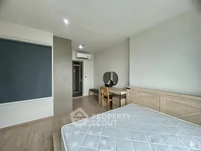 Modern minimalist bedroom with wooden flooring and sleek furniture design