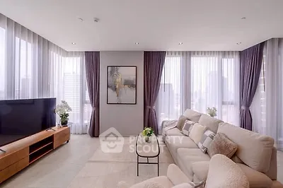 Luxurious modern living room with panoramic city views and elegant decor.