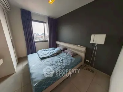 Modern bedroom with city view, featuring a cozy bed and stylish decor.