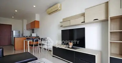 Modern living room with open kitchen, stylish furniture, and air conditioning in a contemporary apartment.