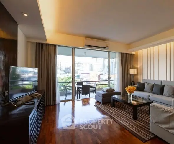 Spacious living room with modern decor and city view balcony access.