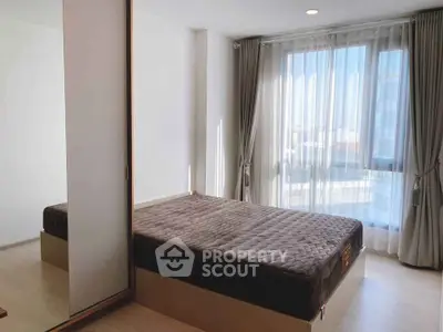 Bright bedroom with large window and modern decor in a stylish apartment.