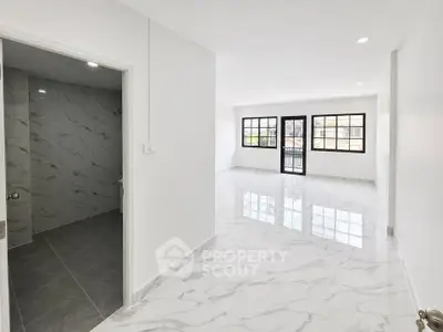 Spacious modern living room with marble flooring and large windows for natural light.